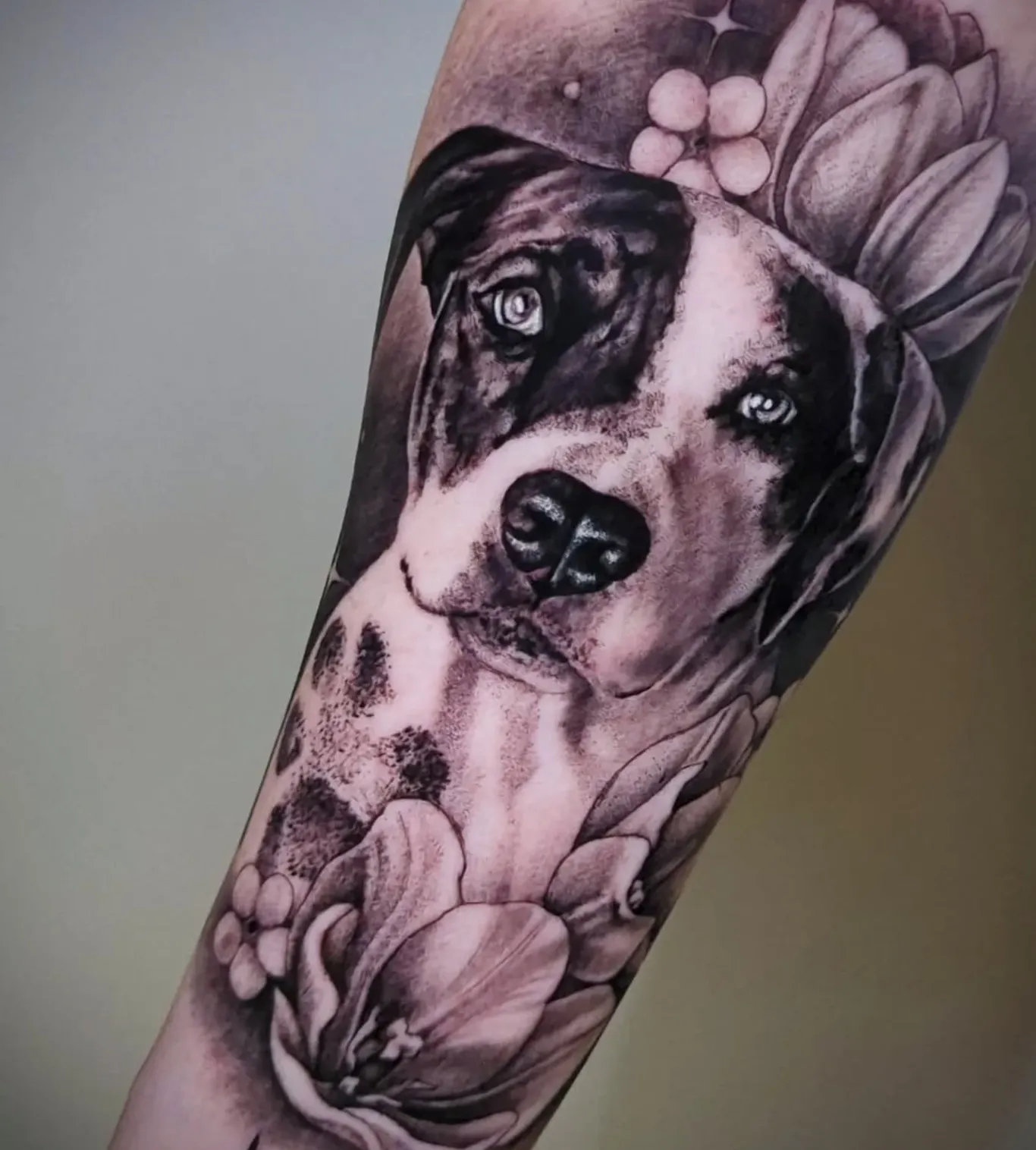 Portrait tattoo of dog with floral elements and decorative background